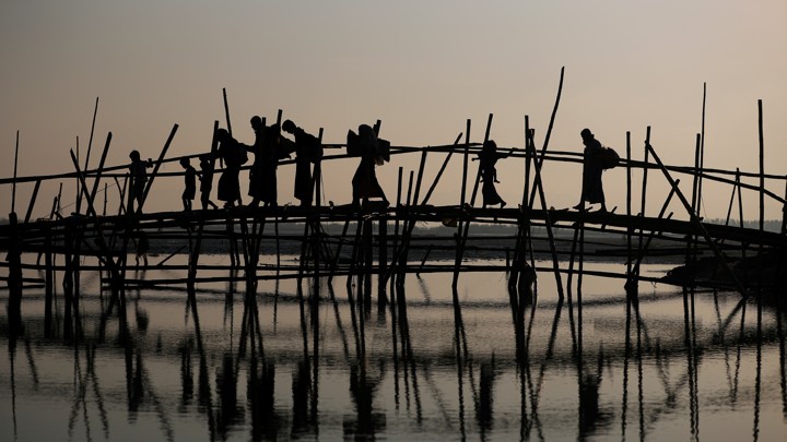 Rohingya refugees cross a bamboo bridge.