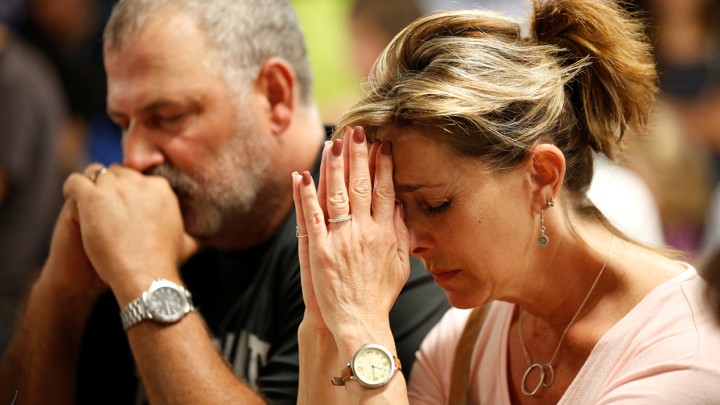 People pray during a vigil for the victims of a mass shooting in Las Vegas.
