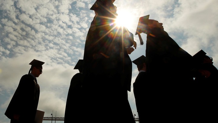 The silhouettes of several college graduates