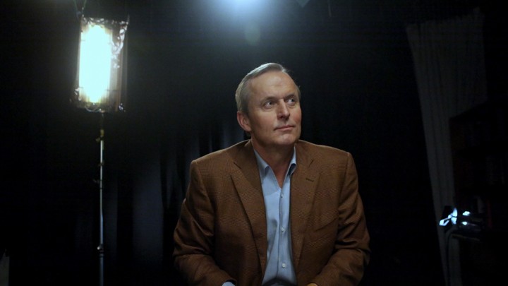 John Grisham sitting below stage lights