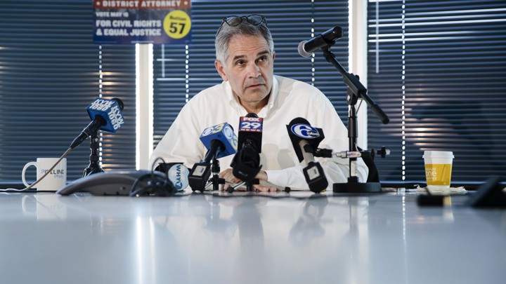 Larry Krasner, the Democratic candidate for district attorney in Philadelphia, sits at a table and speaks into multiple microphones during a news conference in May.