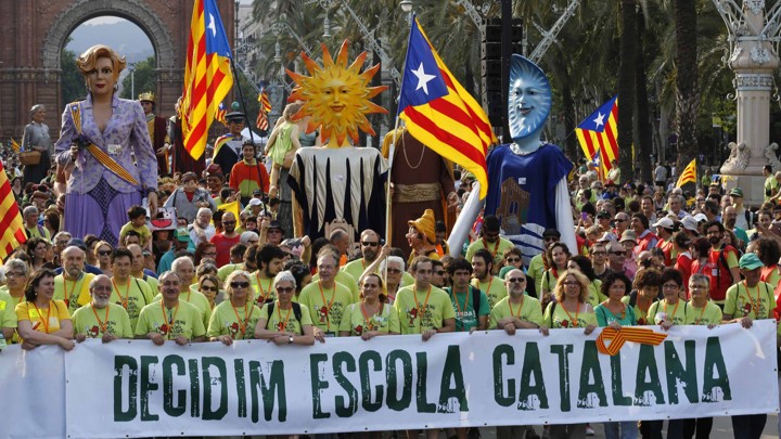 Demonstrators carry a banner, which reads: "Decided, Catalan school."