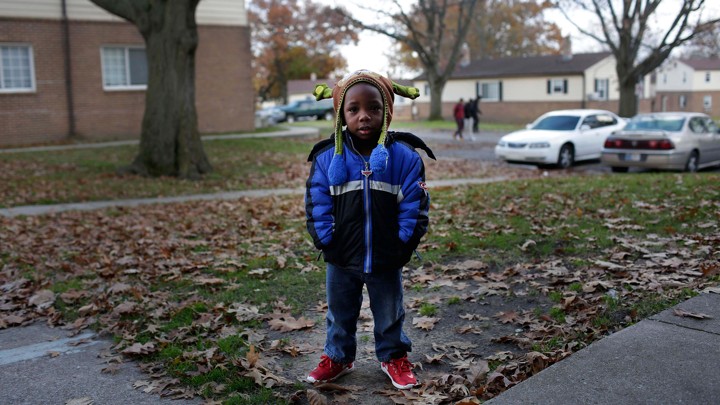 A small boy in a suburban yard