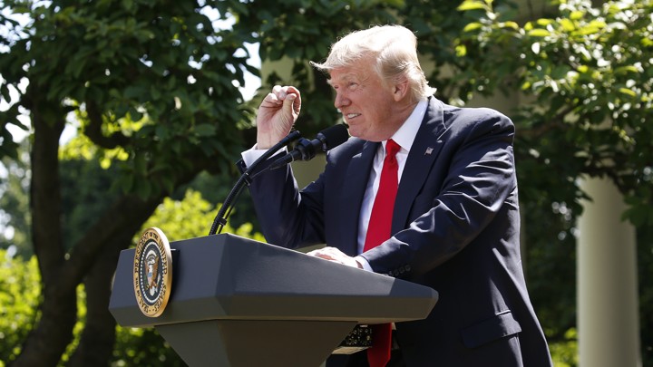 President Donald Trump holds his thumb and forefinger a small distance apart in front of his eye, as he squints, to suggest that the Paris Agreement will only avert a small amount of temperature change.