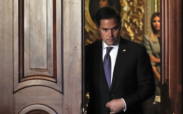 Florida Senator Marco Rubio walks through a doorway.