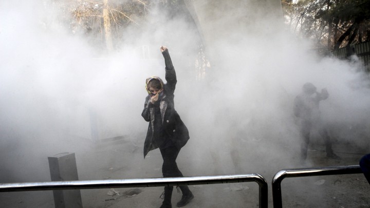 Students attend a protest at Tehran University, where a smoke grenade was thrown by anti-riot Iranian police on December 30, 2017.