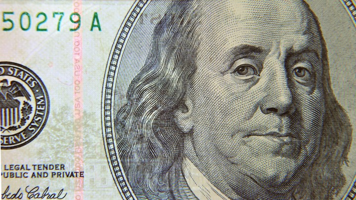 A close-up view of Benjamin Franklin's face on a $100 bill