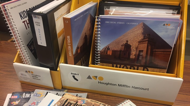 History and social studies textbooks sit on a desk.