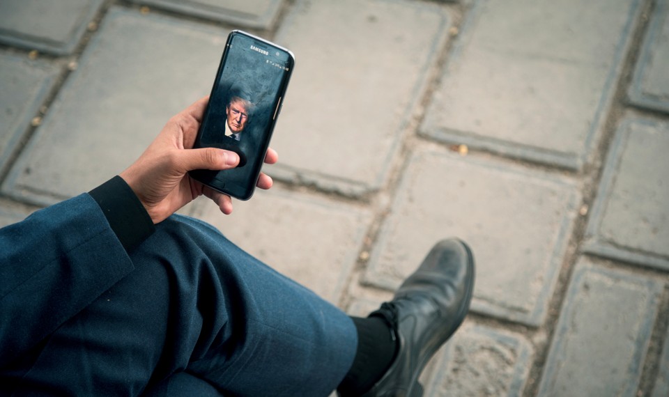 A man displays a picture of President Trump on his phone.