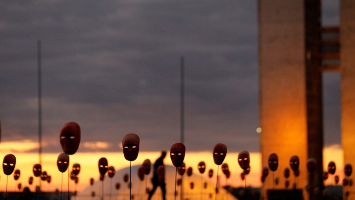 A man walks past masks in Brasilia.