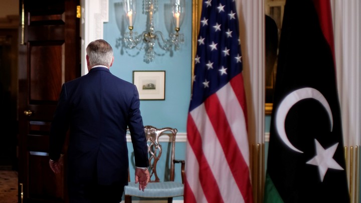 Rex Tillerson walks out of a room.