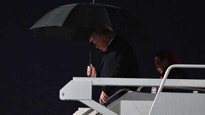 President Trump carrying a black umbrella as he disembarks Air Force One