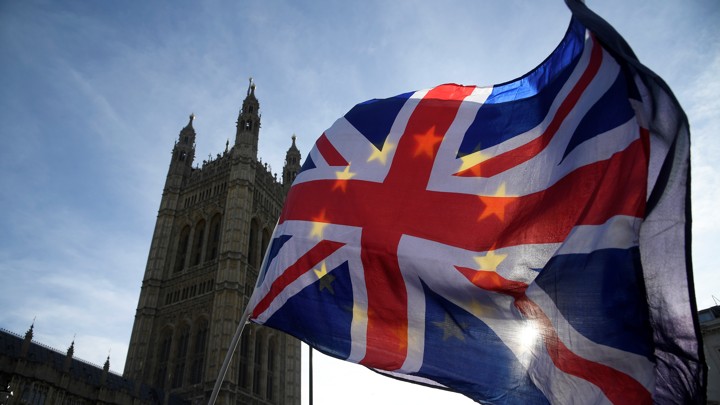 Anti-Brexit demonstrators wave EU and Union flags outside the Houses of Parliament in London on January 30, 2018.
