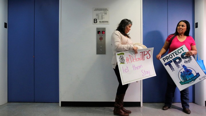 Two Salvadoran immigrants wait for an elevator.