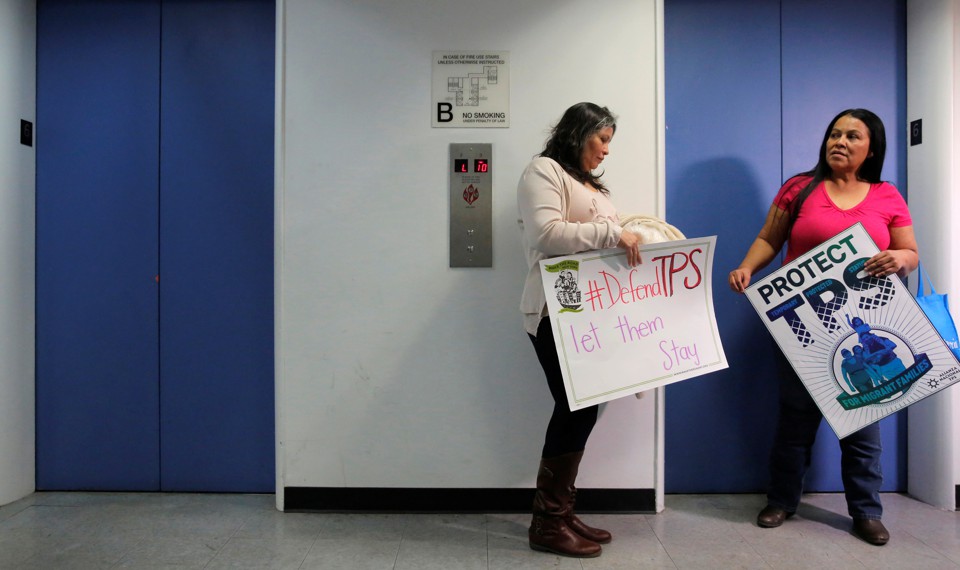 Dos inmigrantes salvadoreños esperan un ascensor.