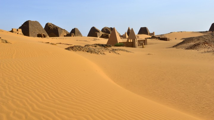 The ruins of several pyramids in the desert sands at Meroë, Sudan