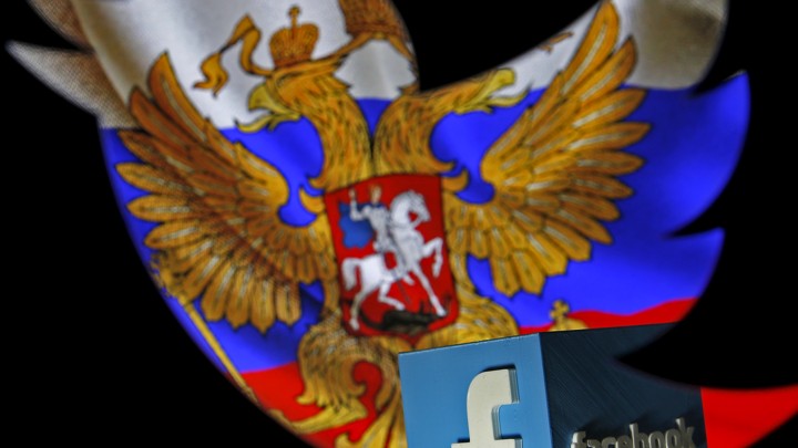 A Russian flag is seen next to the Facebook logo