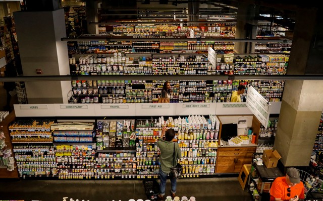 A customer in front of many stocked aisles at a Whole Foods