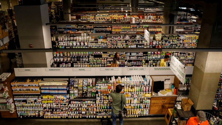 A customer in front of many stocked aisles at a Whole Foods