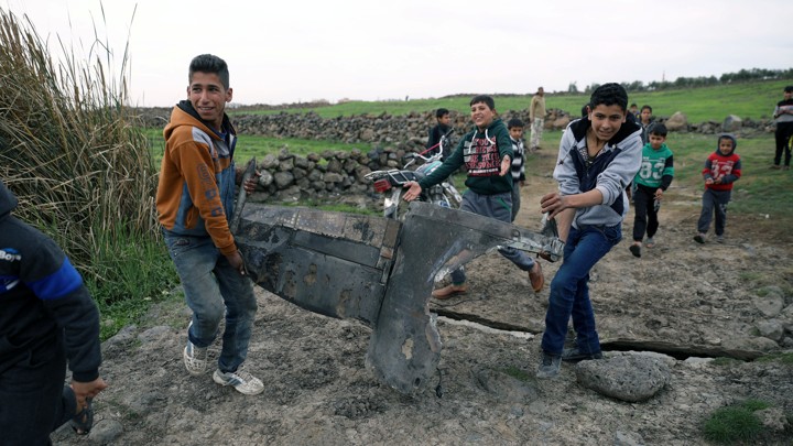 Children carry a part of a missile