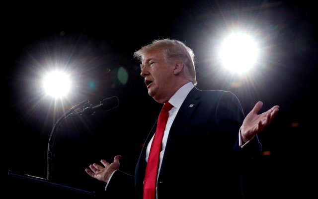 President Donald Trump speaking into a microphone