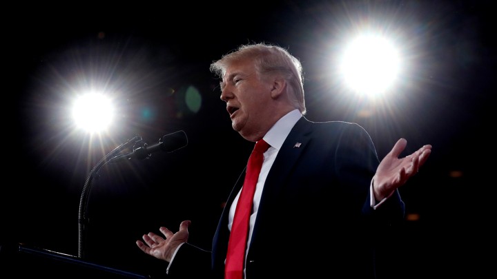 President Donald Trump speaking into a microphone