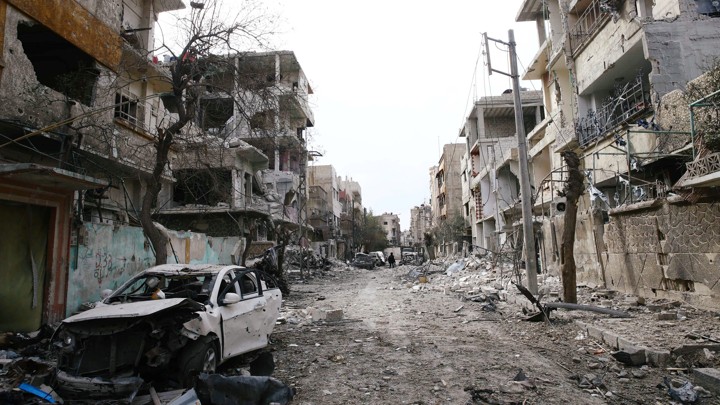 Rubble from damaged buildings fills a street in the besieged Syrian region of eastern Ghouta on February 25, 2018.