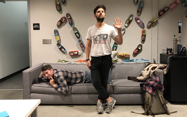Adam Scott and Scott Aukerman posing in the studio where they record the podcast 'R U Talkin' R.E.M. Re: Me?'