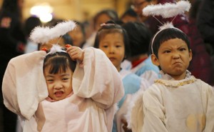 Children dressed as angels attend a Christmas mass at a Catholic church in Beijing.