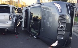 A flipped over grey self-driving SUV