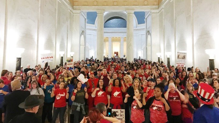 West Virginia teachers in red shirts cheer in the state Capitol after a deal was reached to end their strike.