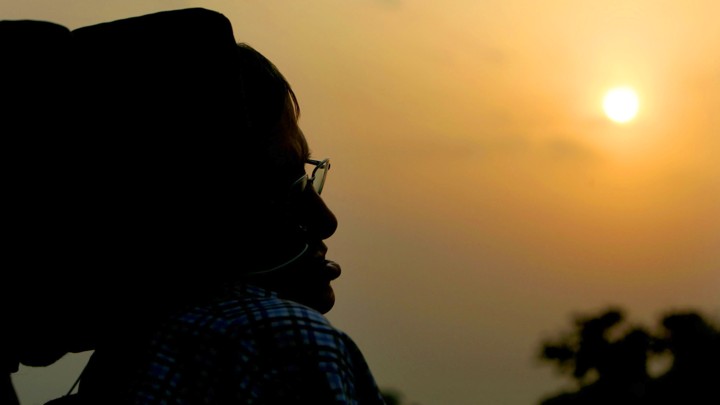 A silhouette of Stephen Hawking against a sunset