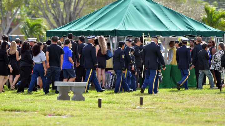 People are seen walking outside of a tent