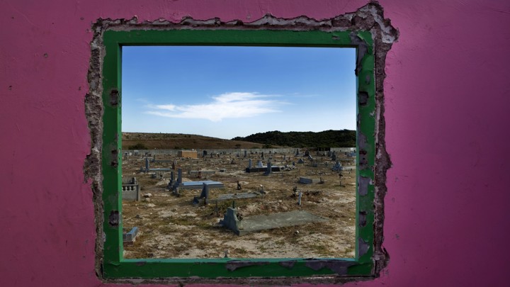 Graves seen through a window in Cape Town's Khayelitsha township