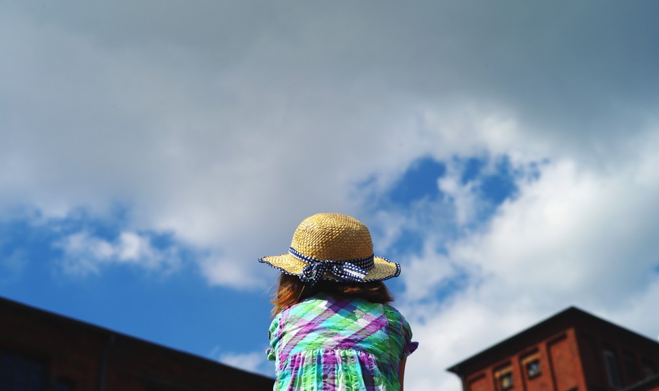 A girl looking at the sky, seen from behind
