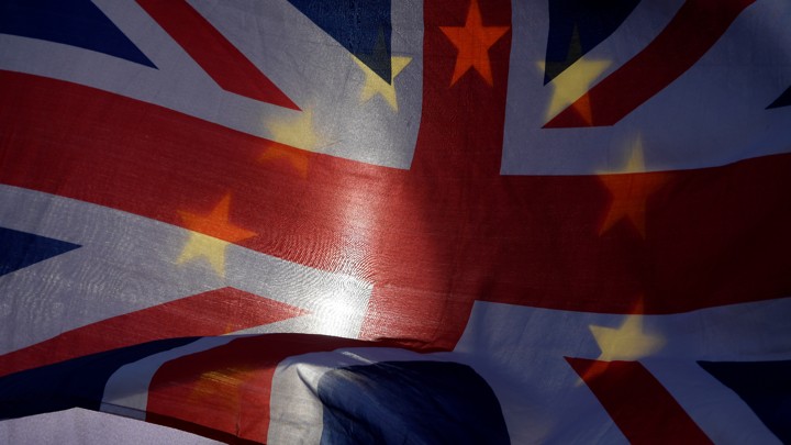 EU and U.K. flags are waved outside the Houses of Parliament in London on January 30, 2018.