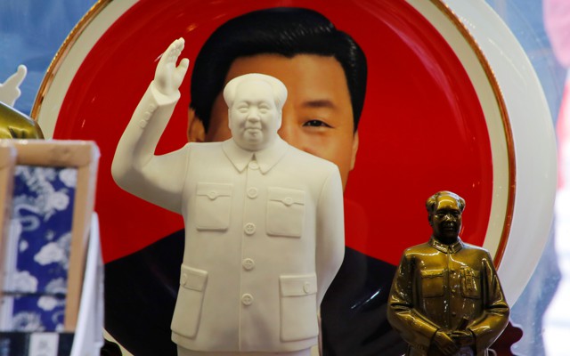 Sculptures of the late Chinese Chairman Mao Zedong in front of a souvenir plate featuring a portrait of Chinese President Xi Jinping at a shop next to Tiananmen Square in Beijing, China, on March 1, 2018.