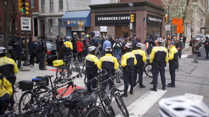 Police stand outside of a Starbucks.