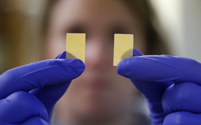 A person wearing purple gloves holds up two slips of suboxone. 