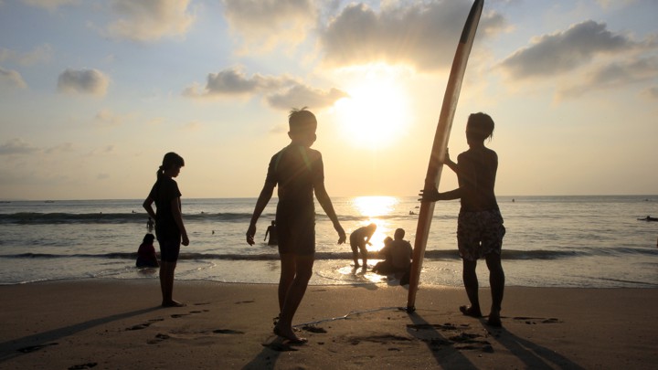 Figures on a beach at sunset