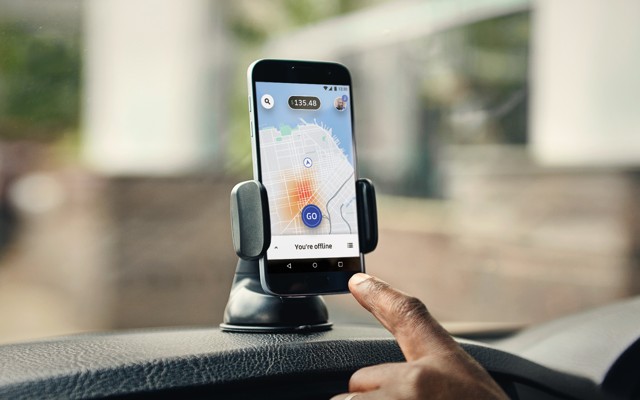 A hand pointing to a smartphone with Uber's app open