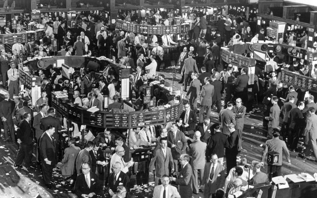 A 1948 black-and-white photograph of the New York Stock Exchange floor, filled with traders