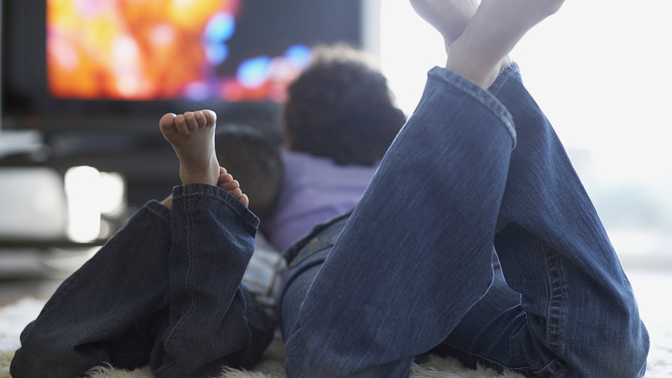 A parent and child watching TV