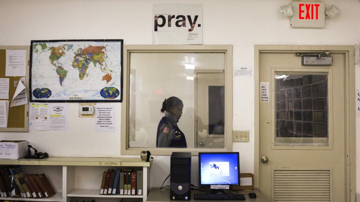 A security official walks past a prison library.