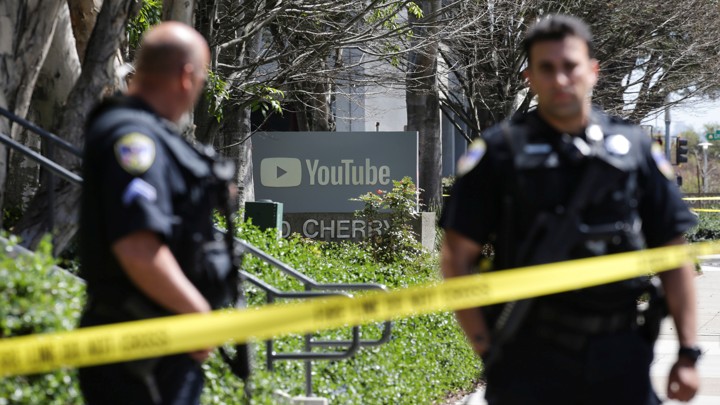 Police officers stand guard outside YouTube headquarters.