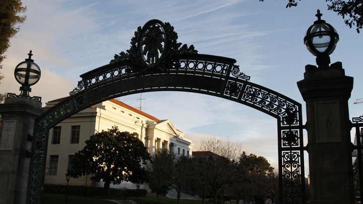 A silhouette of a UC campus gate