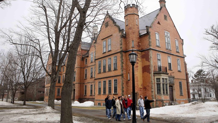 A photo of people walking by a Bowdoin, College campus building.