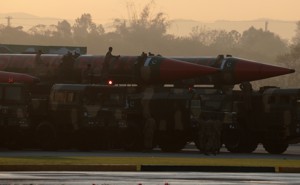 Workers cleaning missiles on transports