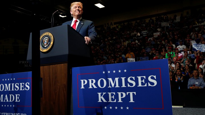 President Donald Trump stands at a lectern during a campaign rally.