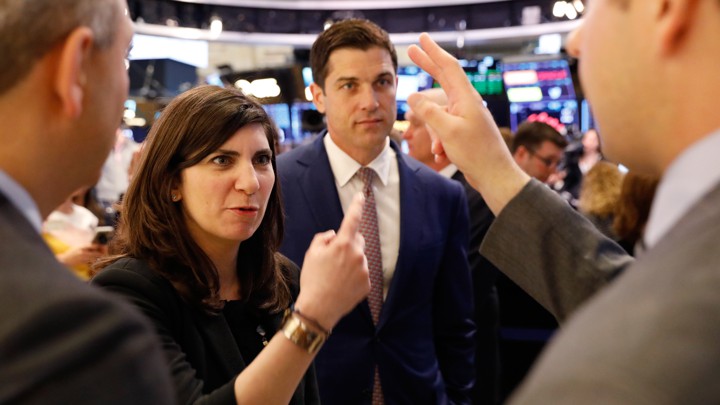 Stacey Cunningham in conversation with three men at the New York Stock Exchange